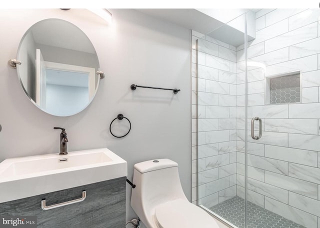 bathroom with vanity, a shower with door, and toilet