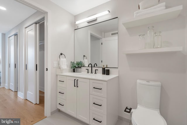 bathroom with vanity, wood-type flooring, and toilet