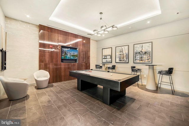 rec room with a raised ceiling and pool table