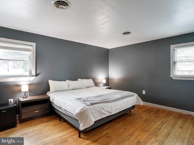 bedroom featuring multiple windows and light wood-type flooring