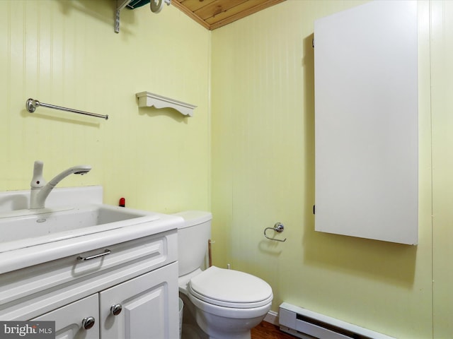 bathroom featuring baseboard heating, vanity, and toilet