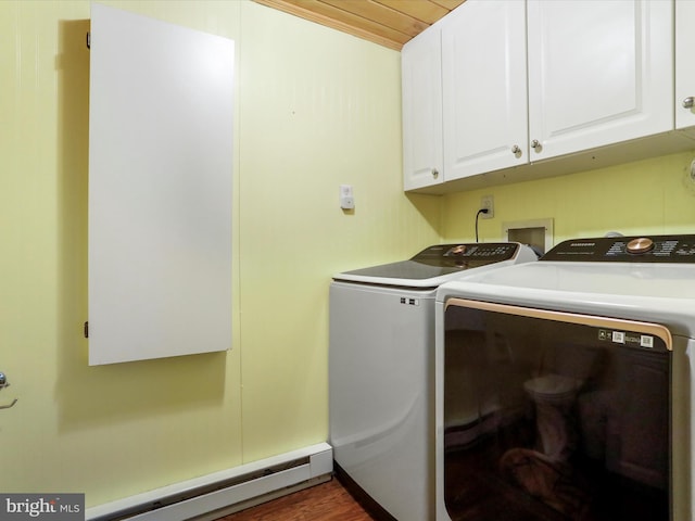 clothes washing area with dark wood-type flooring, cabinets, a baseboard radiator, and separate washer and dryer