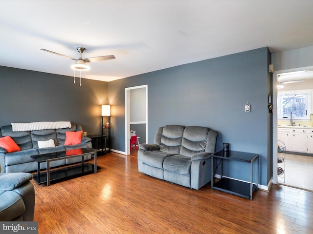 living room with hardwood / wood-style flooring, ceiling fan, and sink