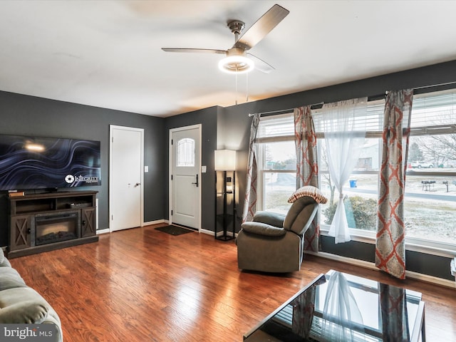 living room with dark hardwood / wood-style flooring and ceiling fan