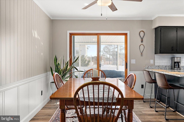 dining room with ceiling fan, ornamental molding, and light hardwood / wood-style flooring