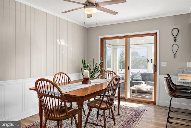 dining space with ceiling fan, ornamental molding, and light hardwood / wood-style flooring