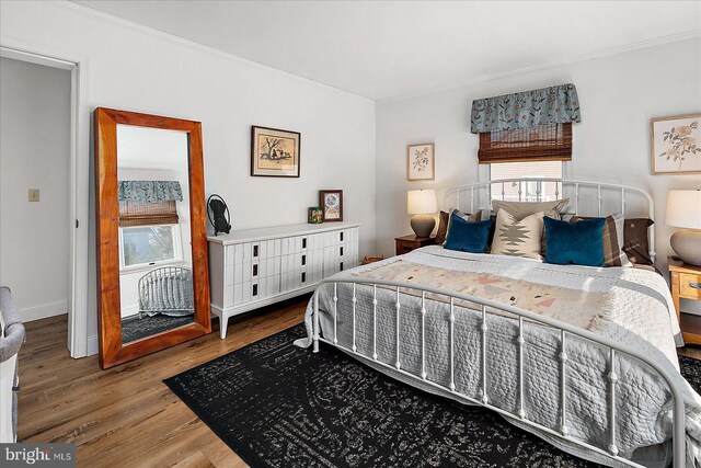 bedroom with wood-type flooring and ornamental molding