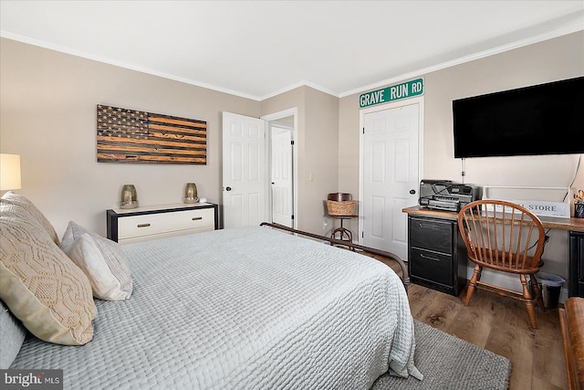 bedroom with crown molding and dark hardwood / wood-style floors