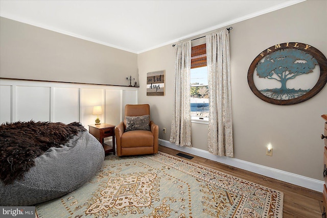 living area with crown molding and hardwood / wood-style floors