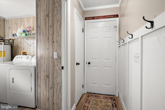 clothes washing area with crown molding, wood-type flooring, separate washer and dryer, and gas water heater