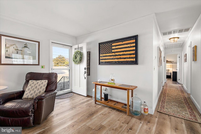 interior space with ornamental molding and light hardwood / wood-style flooring