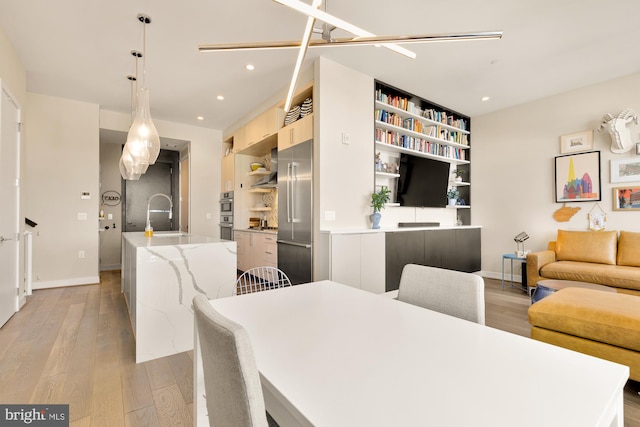 dining room with sink and light wood-type flooring