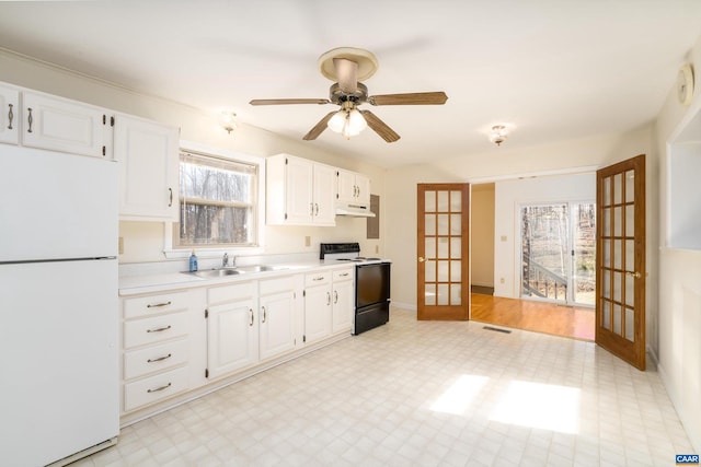 kitchen featuring electric range oven, white cabinetry, sink, white fridge, and french doors