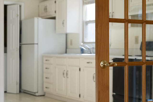 kitchen with white refrigerator and white cabinets