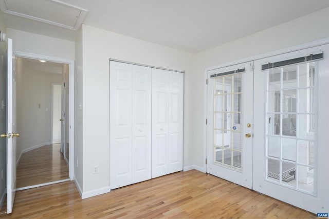 unfurnished bedroom with a closet, hardwood / wood-style floors, and french doors