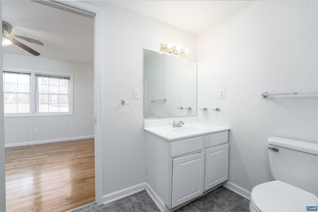 bathroom with hardwood / wood-style flooring, ceiling fan, vanity, and toilet