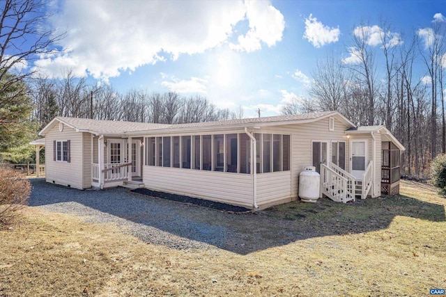 back of house with a yard and a sunroom