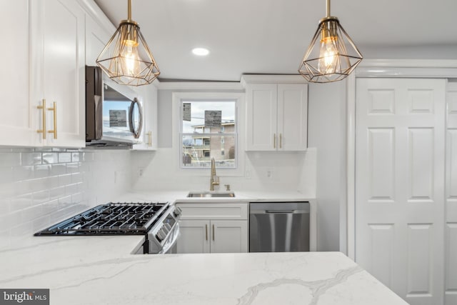 kitchen featuring sink, white cabinetry, light stone counters, hanging light fixtures, and stainless steel appliances