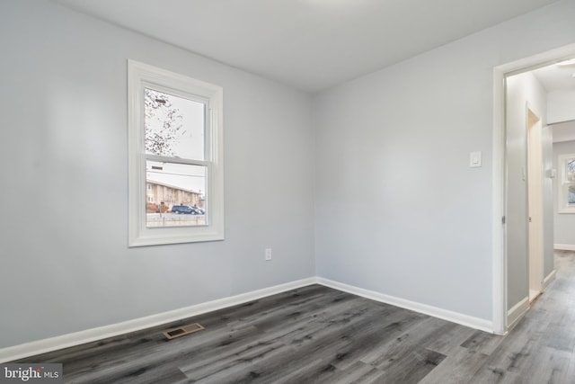 unfurnished room with dark hardwood / wood-style flooring