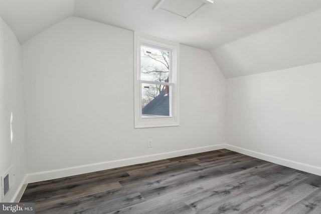 bonus room featuring vaulted ceiling and dark wood-type flooring