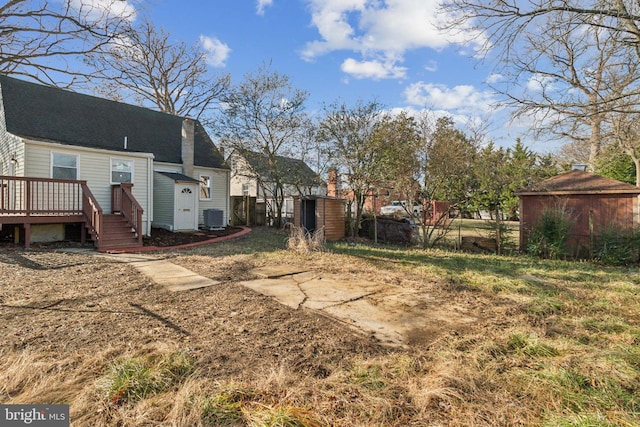 view of yard with a shed, central AC unit, and a deck