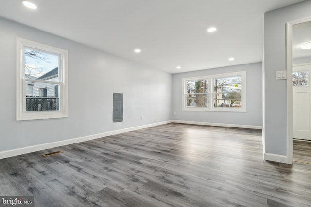 empty room with dark wood-type flooring and electric panel