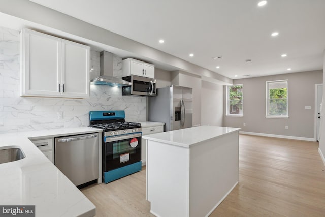 kitchen with white cabinetry, backsplash, a center island, stainless steel appliances, and wall chimney exhaust hood