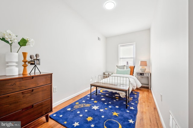 bedroom with hardwood / wood-style floors and vaulted ceiling