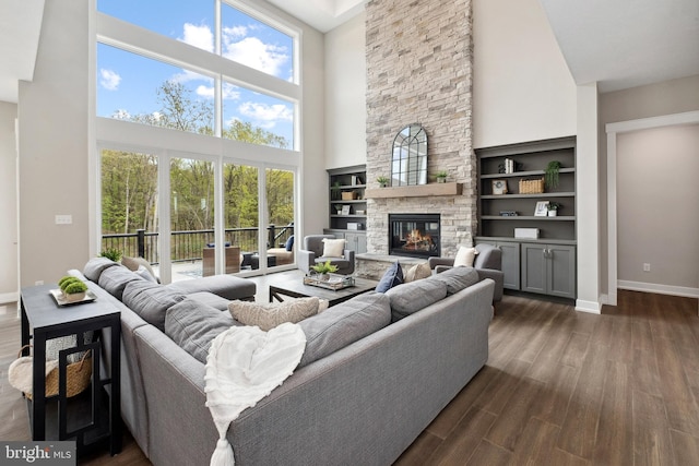 living room featuring a high ceiling, dark hardwood / wood-style floors, and a fireplace