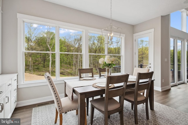 dining space with dark hardwood / wood-style floors and a notable chandelier