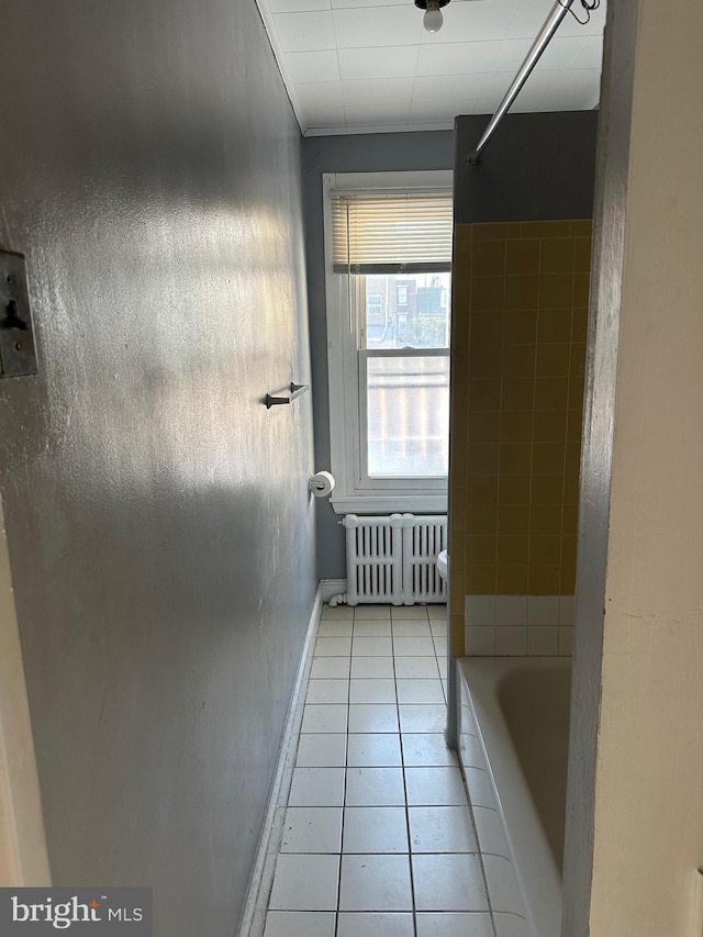 bathroom featuring radiator, a bathtub, and tile patterned floors