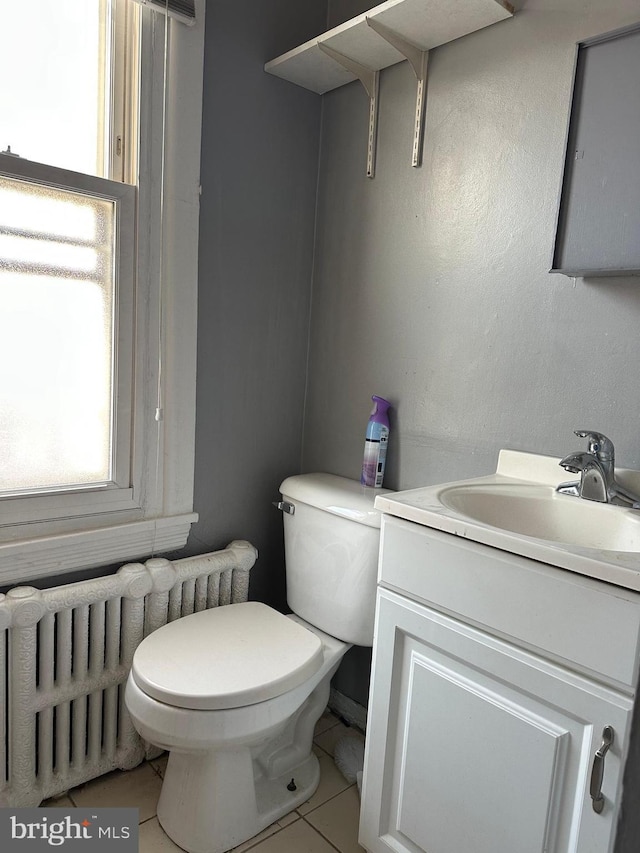 bathroom featuring vanity, radiator heating unit, and toilet