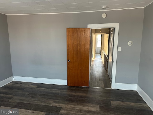 spare room with crown molding and dark hardwood / wood-style floors