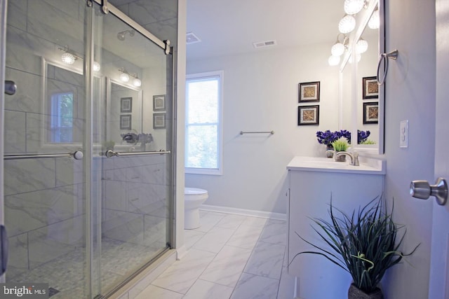 bathroom with a shower with door, vanity, and toilet