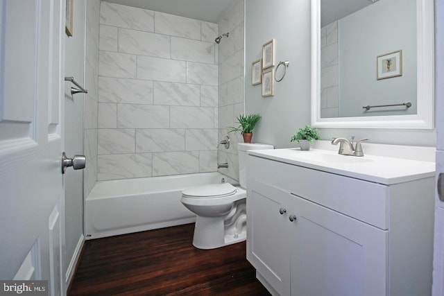 full bathroom with wood-type flooring, tiled shower / bath, vanity, and toilet