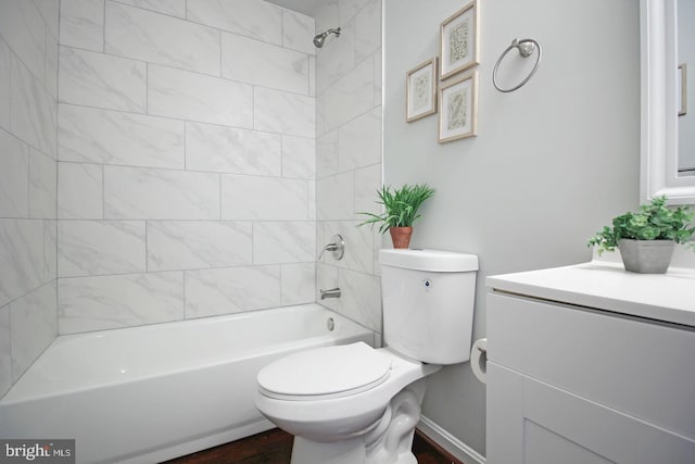 full bathroom featuring tiled shower / bath combo, vanity, and toilet