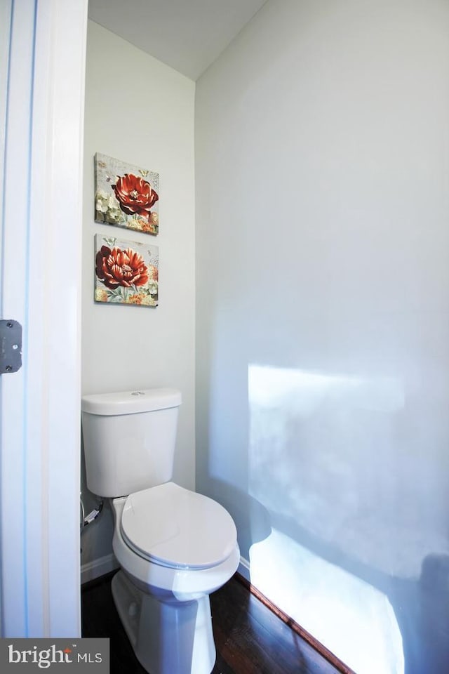 bathroom with hardwood / wood-style flooring and toilet