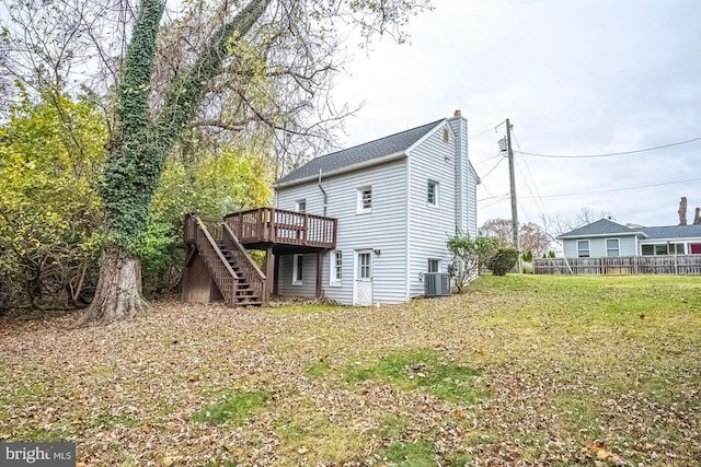 back of property featuring a wooden deck, a lawn, and central air condition unit