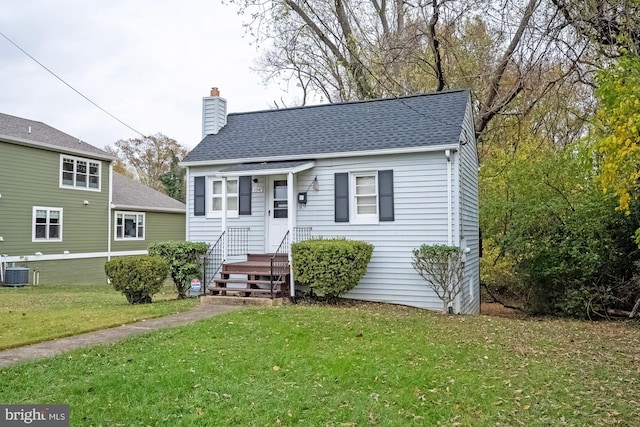 view of front of house with central AC unit and a front lawn