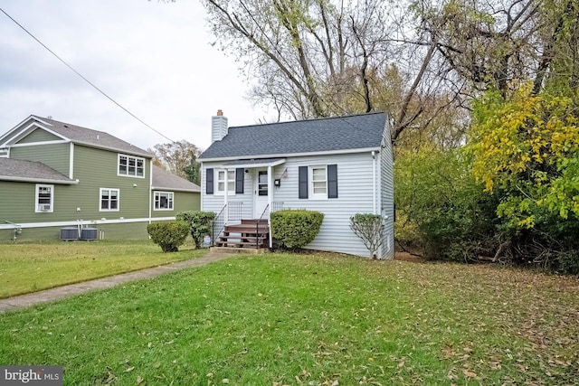 bungalow-style home featuring cooling unit and a front yard