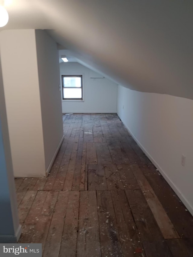 additional living space with vaulted ceiling and dark wood-type flooring