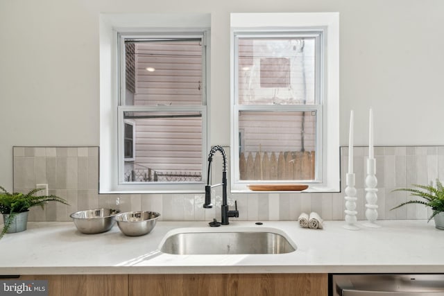 details featuring tasteful backsplash, sink, and dishwasher