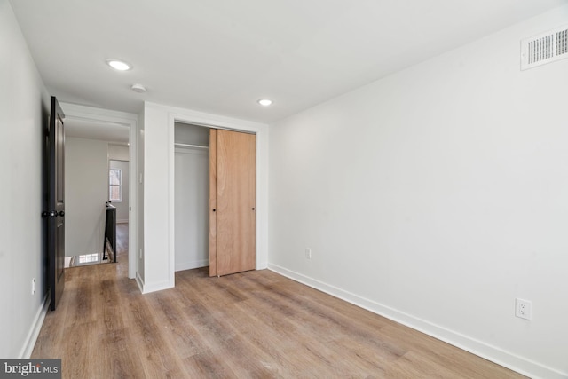 unfurnished bedroom with a closet and light hardwood / wood-style flooring