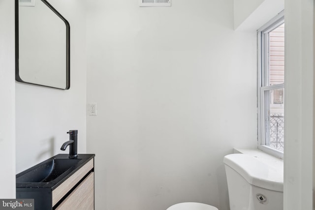 bathroom featuring a healthy amount of sunlight, toilet, and vanity