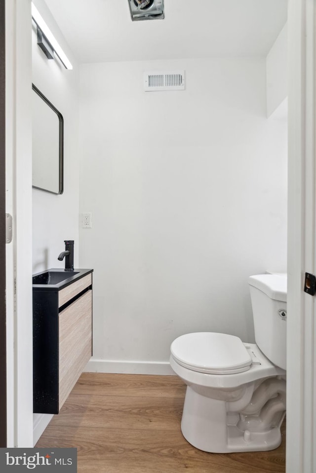 bathroom with vanity, wood-type flooring, and toilet