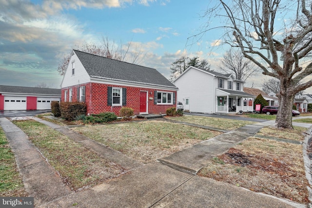 view of front of property with an outbuilding, a garage, and a front lawn