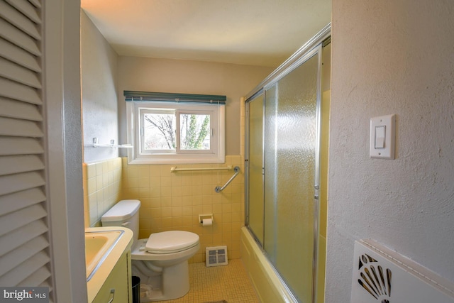 bathroom with tile walls, vanity, tile patterned flooring, and toilet