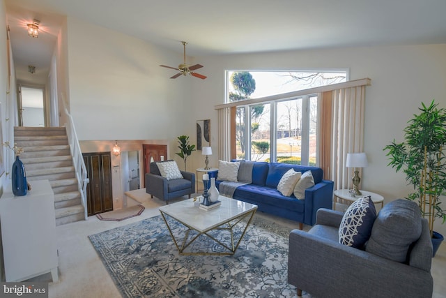 living room with light colored carpet, ceiling fan, and a high ceiling