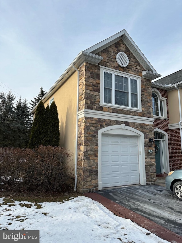 view of snowy exterior featuring a garage