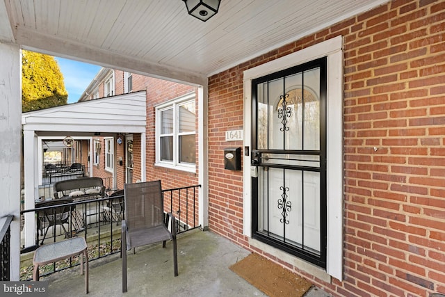 view of exterior entry featuring brick siding